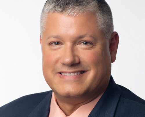Headshot of Charlie Hanna, Chief Revenue Officer at EOX Vantage, smiling against a neutral background.