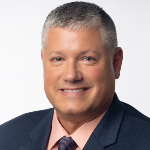 Headshot of Charlie Hanna, Chief Revenue Officer at EOX Vantage, smiling against a neutral background.