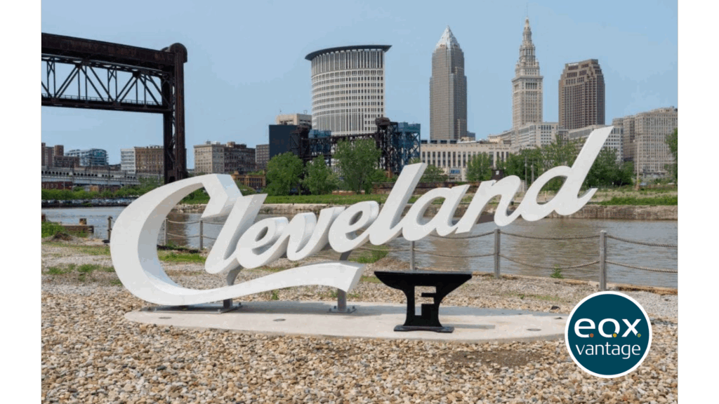 Large Cleveland script sign with the Foundry logo along the Cuyahoga river in front of the Cleveland skyline